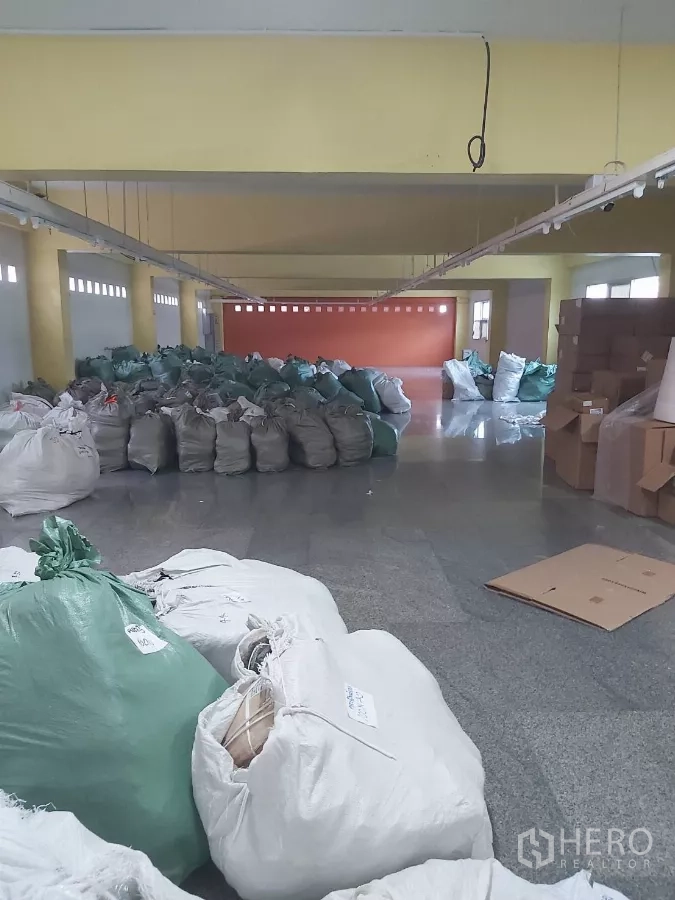 Warehouse for rent in Krathum Baen, Samut Sakhon - Deep warehouse aisle filled with bagged inventory and cartons.