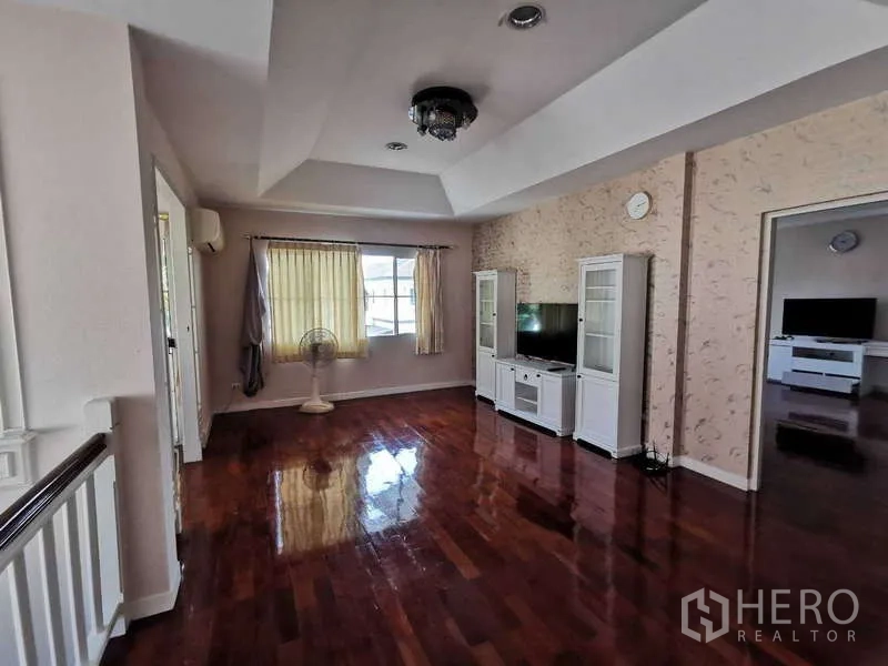 Detached House for rent - Upstairs family lounge with polished wooden floors, TV cabinet, ceiling light, and access to adjacent bedrooms.
