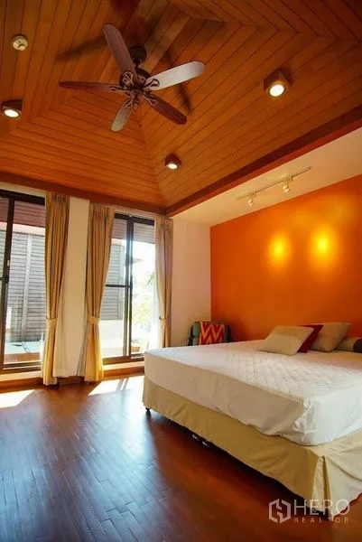 ทาวน์เฮาส์ ให้เช่าในWatthana, Bangkok - ห้องนอนฝ้าไม้พร้อมพัดลมเพดานและประตูกระจกออกระเบียง