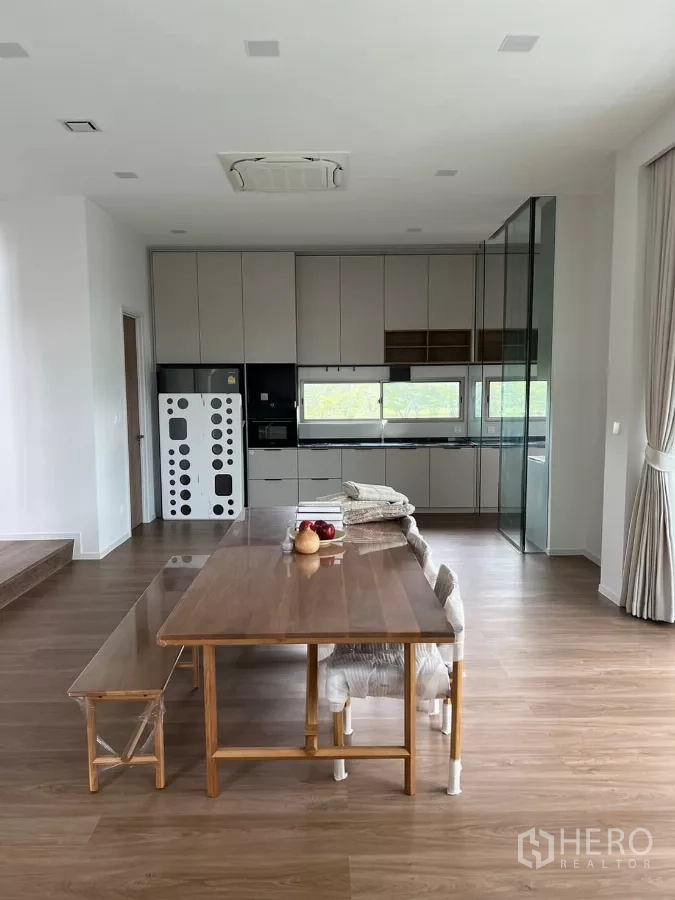Detached House for rent in Saphan Sung, Bangkok - Dining area adjoining a full kitchen with glass partition and built-in appliances.