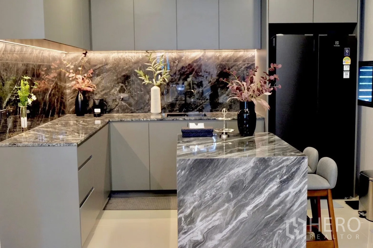 半独立式住宅 for sale in Prawet, Bangkok - U形厨房，石材台面与挡板，配黑色冰箱。