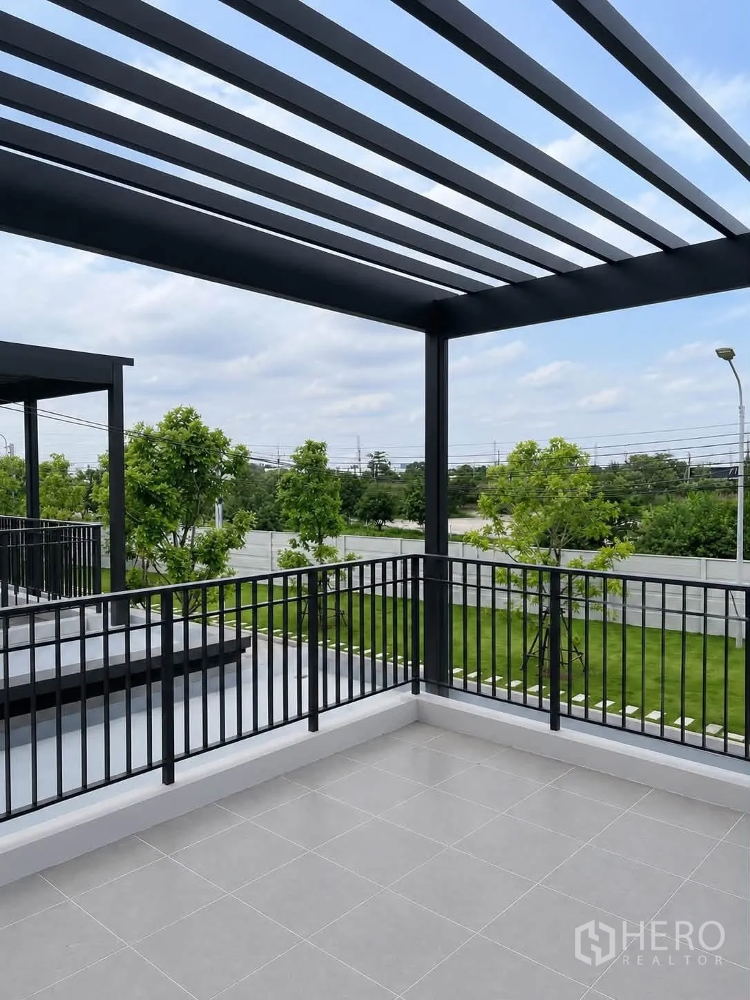 Detached House for rent in Bang Phli, Samut Prakan - Upper terrace with black pergola and railing overlooking landscaped greenery.