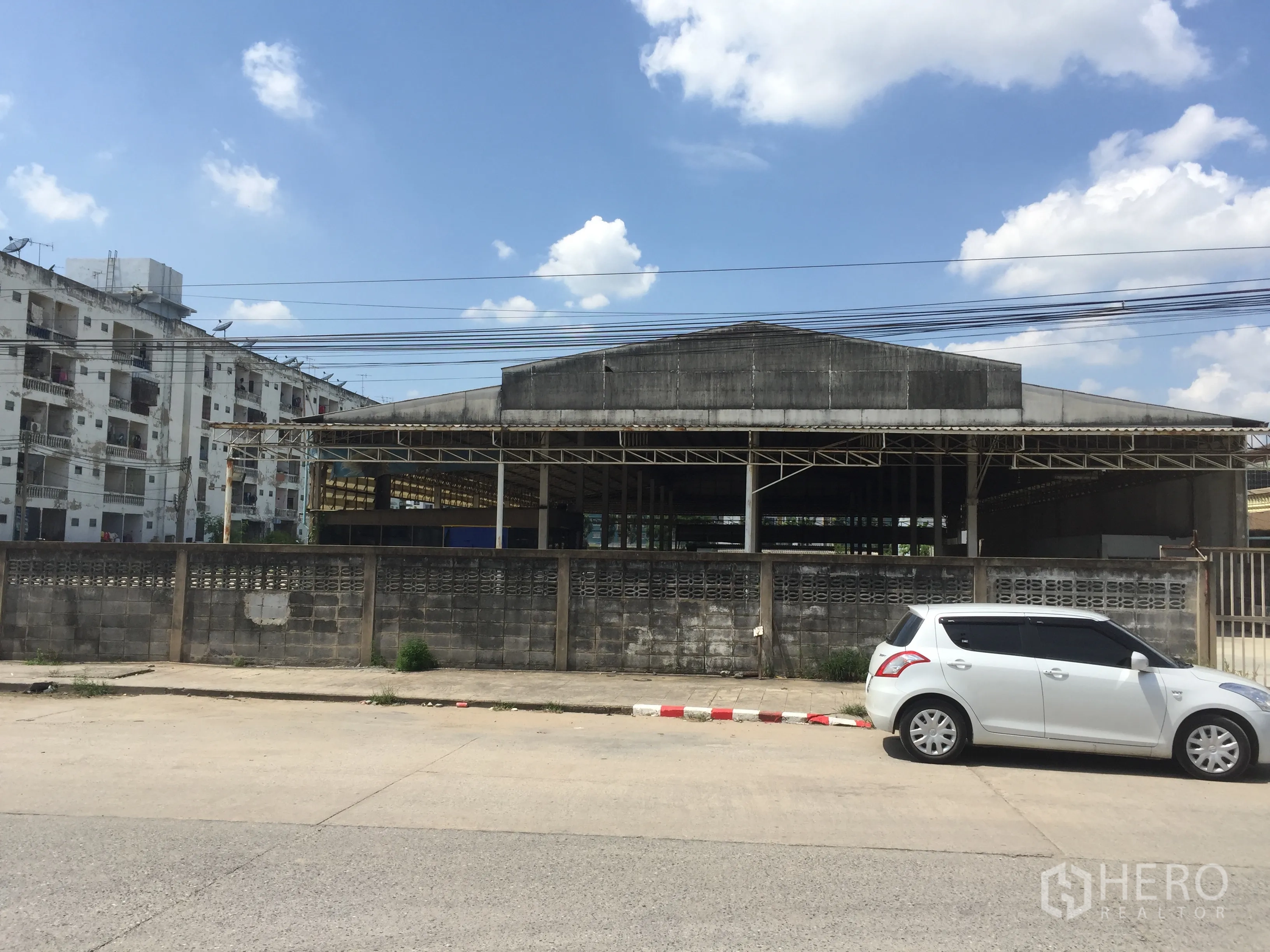 货栈 出租在Khlong Luang, Pathum Thani - 面向街道的仓库外观，带围墙与大门，卡车进出便捷，位于空銮。