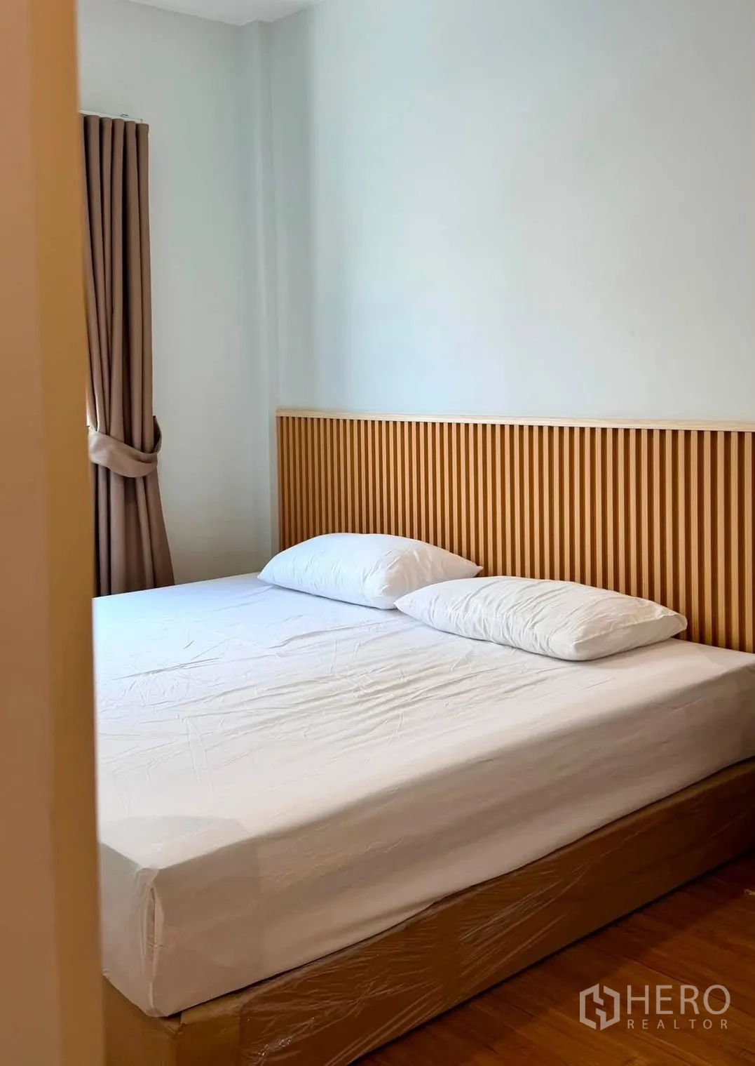 ทาวน์เฮาส์ for rent in Bang Phli, Samut Prakan - ห้องนอนอบอุ่นพร้อมเตียงคู่ เฮดบอร์ดไม้ระแนง และผ้าม่าน.