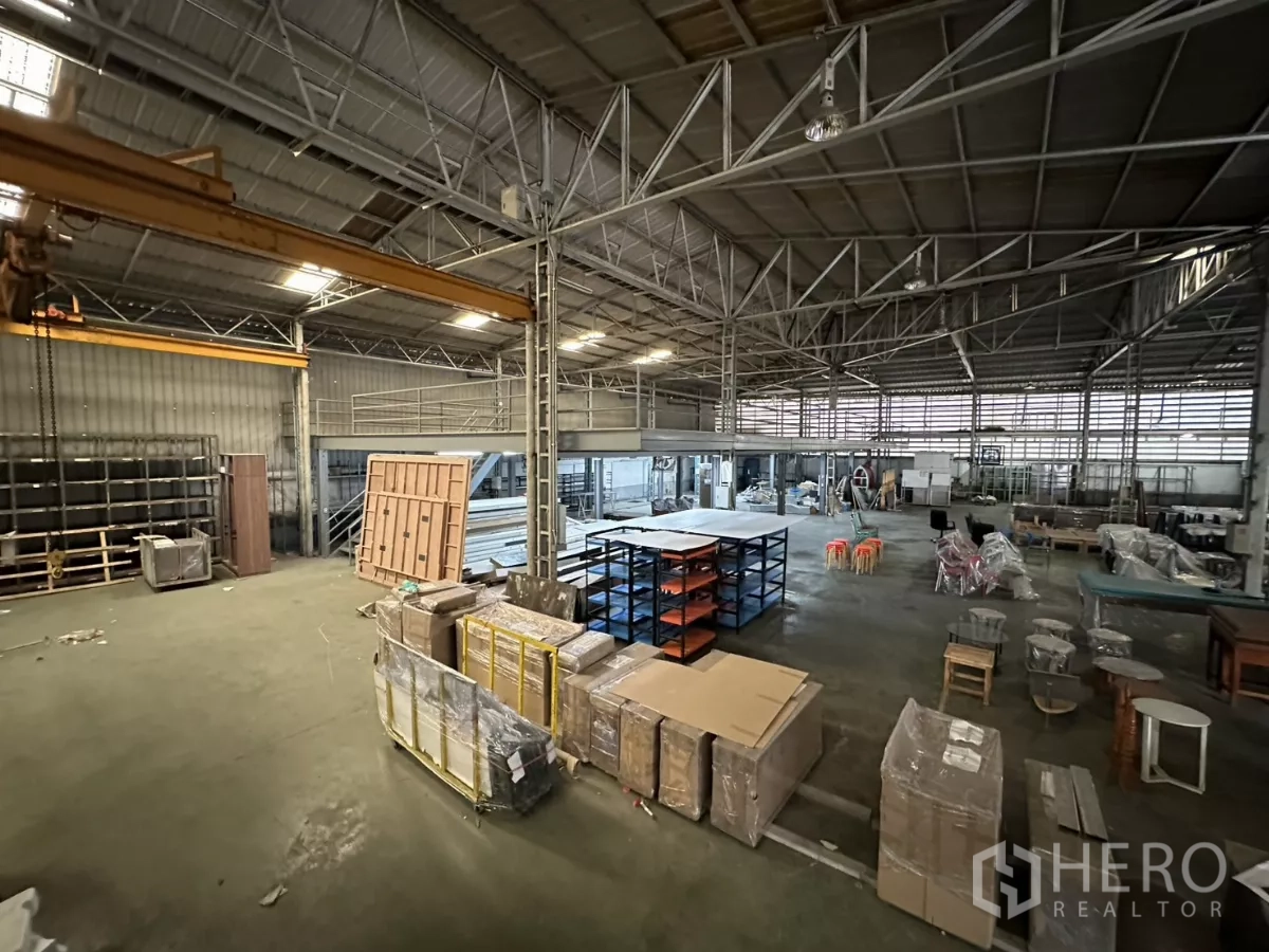 Warehouse for rent in Yan Nawa, Bangkok - Overhead gantry crane spanning the central bay above pallets and packing area.