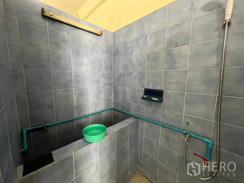 Shophouse for sale in Phra Khanong, Bangkok - Second blue‑tiled bathroom featuring Thai water tub and shower set.