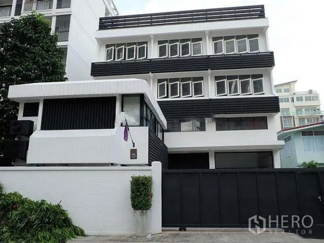 Home Office for sale in Khlong Toei, Bangkok - Four-storey home office exterior with black-and-white facade and sliding gate.