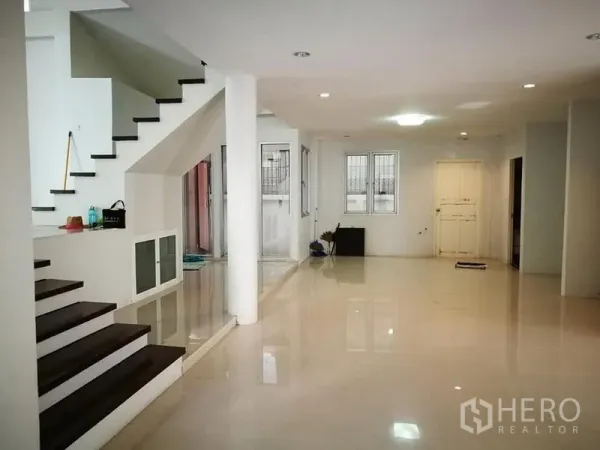 Detached House for rent in Phra Khanong, Bangkok - Open-plan ground floor with a modern staircase, columns, and polished floors.