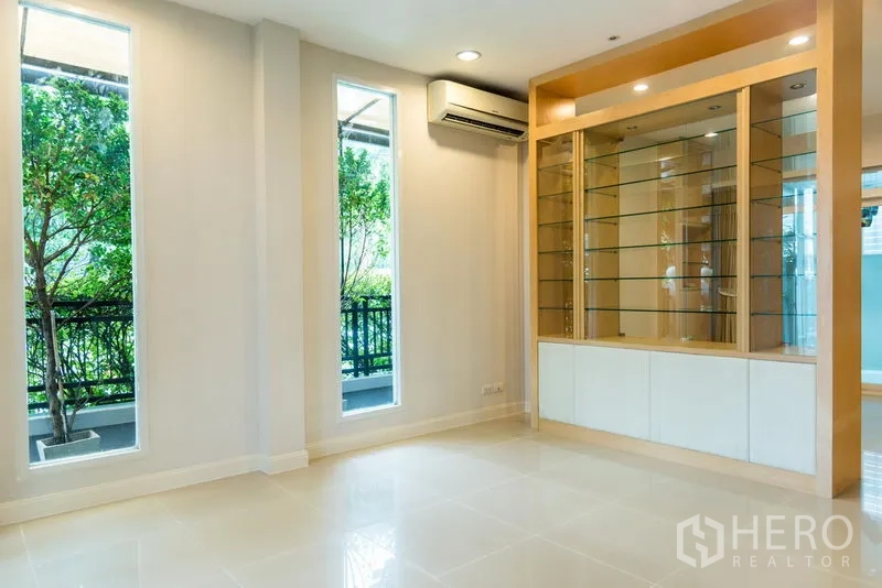 联排别墅 出售在Wang Thonglang, Bangkok - 次客厅，内置展示柜与高窗，窗外绿景。