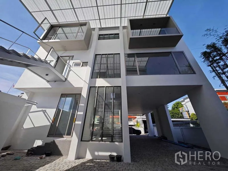 Home Office for rent or sale - Contemporary white facade with tall windows, balconies and a covered carport.