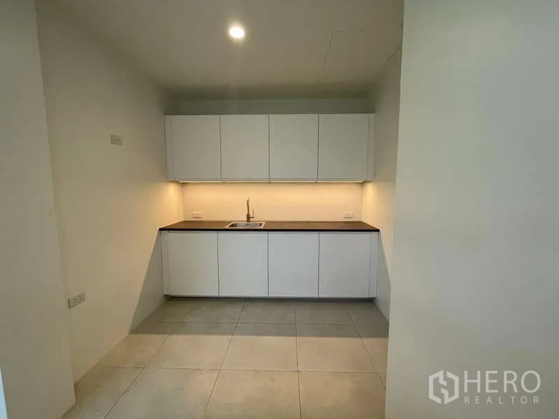 Home Office for rent in Don Mueang, Bangkok - Built-in pantry kitchen with white cabinets and under-cabinet lighting.