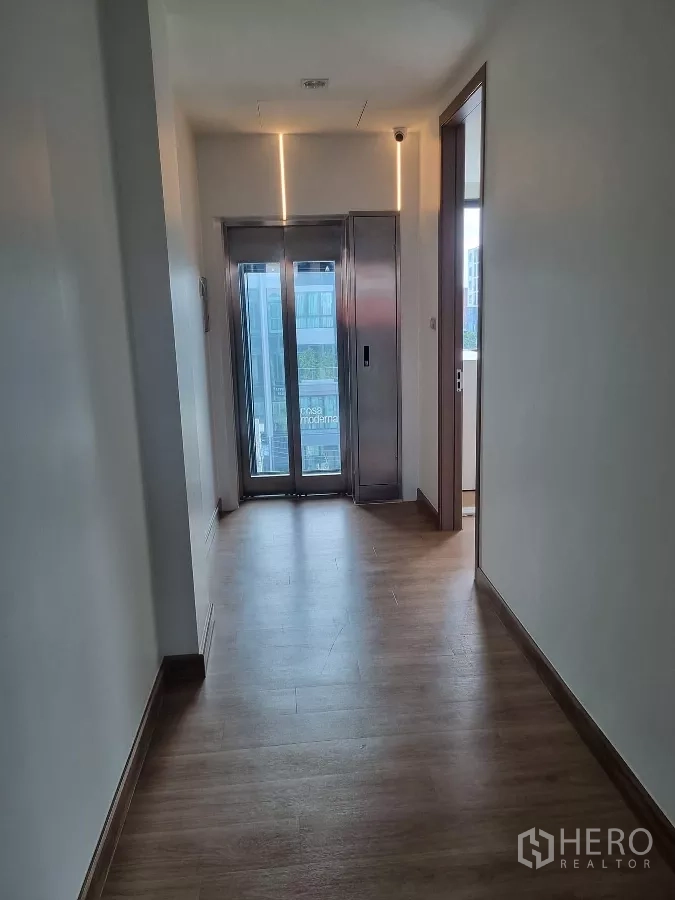 Home Office for rent in Khlong Toei, Bangkok - Upper hallway featuring a private glass elevator at the end.
