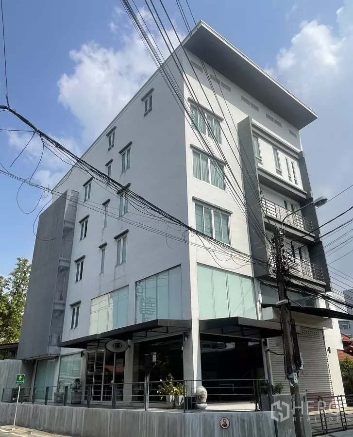 带办公室的家 出租在Suan Luang, Bangkok - 4.5层现代家居式办公楼外观，转角玻璃立面与雨棚，位于曼谷素安隆区拉玛9沿线。
