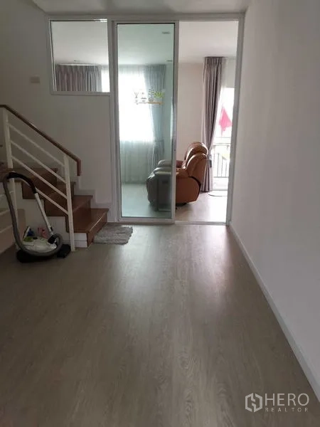 带办公室的家 出租或出售 - 楼层走道与楼梯，通过玻璃推拉门进入休闲室。