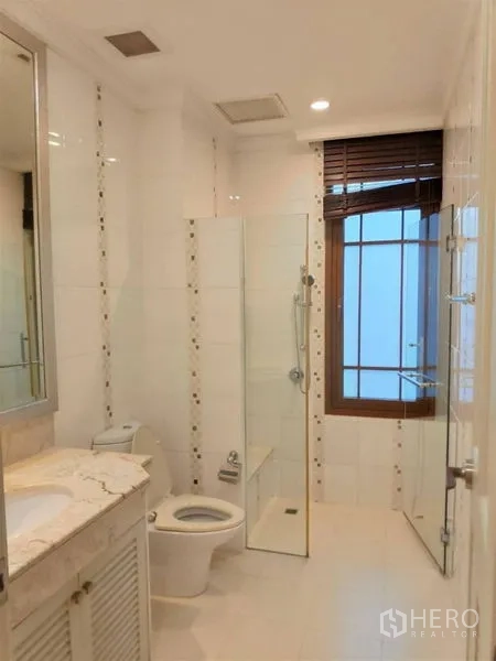 独立式住宅 出租在Watthana, Bangkok - 白色瓷砖浴室，玻璃淋浴间、洗手台与采光窗。
