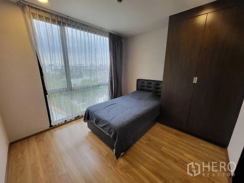 Condominium for rent or sale in Phaya Thai, Bangkok - Second bedroom with single bed, wardrobe and floor-to-ceiling window.
