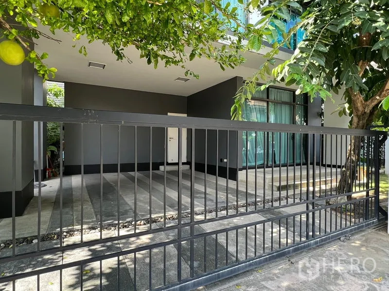 Detached House for rent or sale in Bang Kapi, Bangkok - Covered carport and gated entrance shaded by mature trees.