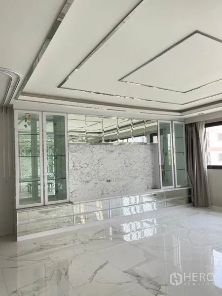 Townhouse for rent or sale in Yan Nawa, Bangkok - Bright upstairs room with coffered ceiling, mirrored cabinetry, and marble-look tiles.