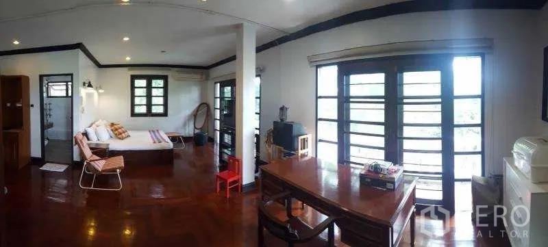 独立式住宅 出租在Bang Phli, Samut Prakan - 二楼家庭活动室，阳台门、书桌与亮丽木地板。