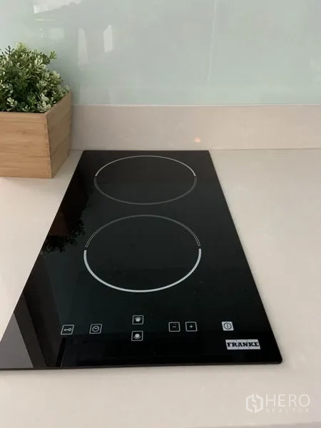 Condominium for rent or sale in Khlong Toei, Bangkok - Close-up of a two-burner induction cooktop on a white countertop.