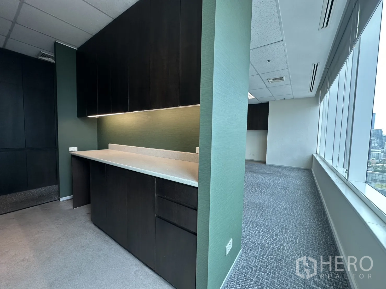 Office Space for rent in Watthana, Bangkok - Pantry or workroom with upper cabinets, long countertop, and green accent wall.