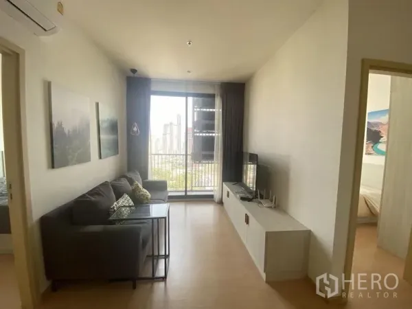 Condominium for rent in Watthana, Bangkok - Another view of the living room opening to a balcony overlooking Ekkamai’s cityscape.
