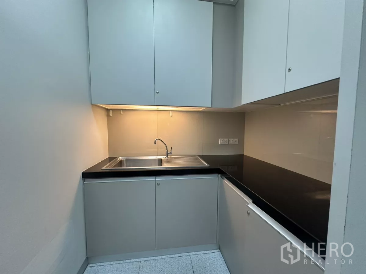 Office Space for rent in Watthana, Bangkok - Compact pantry with sink, upper cabinets and black countertop.