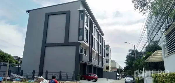 带办公室的家 出售在Huai Khwang, Bangkok - 现代多层住办合一建筑，带停车区与围栏入口。