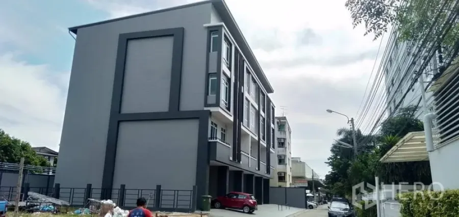Home Office for sale in Huai Khwang, Bangkok - Modern multi-storey home office building with parking area and a gated entrance.