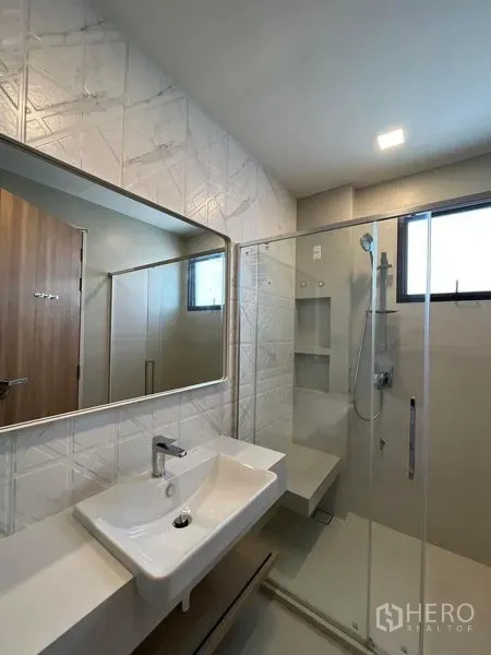 Detached House for rent or sale - Second bathroom featuring geometric wall tiles, long vanity mirror, and clear glass shower.