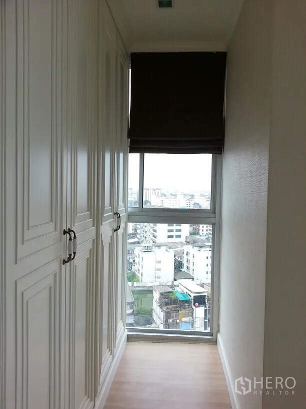 公寓 出租或出售在Watthana, Bangkok - 明亮步入式衣帽间，白色嵌入式衣柜与观景大窗。