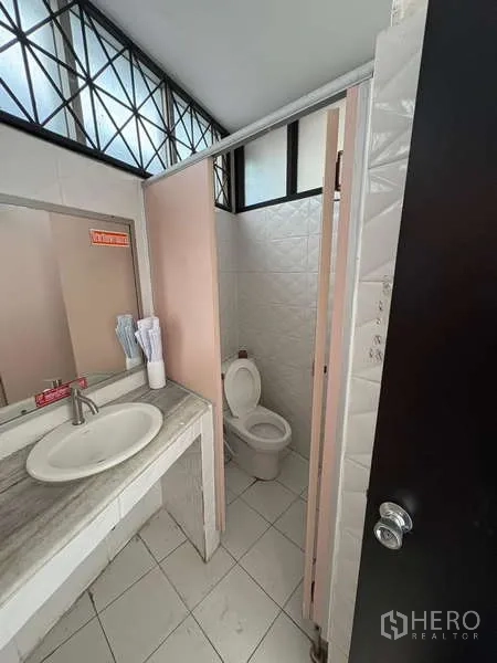 办公空间 出租在Khlong Toei, Bangkok - 干净卫生间，含洗手池、镜子与隔间马桶。