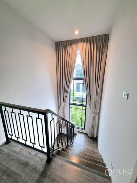 独立式住宅 出租 - 金属栏杆楼梯，配高窗与窗帘。