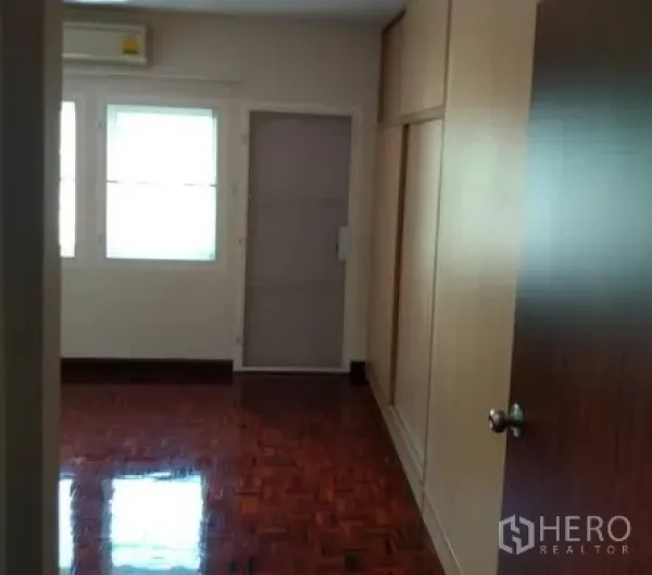 Apartment for rent in Pathum Wan, Bangkok - Bedroom corridor with built-in wardrobes, parquet flooring and air conditioner in Bangkok apartment.