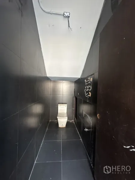 带办公室的家 出租在Pathum Wan, Bangkok - 狭长的黑色瓷砖卫生间，坐便器与外露管线。