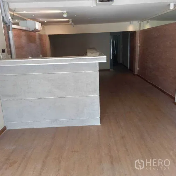Shophouse for rent in Watthana, Bangkok - Ground-floor retail area with reception counter, wood flooring and track lights
