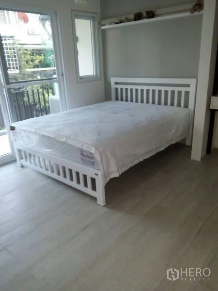 联排别墅 出售在Khlong Toei, Bangkok - 第二卧室，落地阳台门、转角窗与浅色木地板。