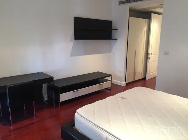 公寓 出租在Pathum Wan, Bangkok - 卧室铺设木地板，带书桌、壁挂搁架与衣柜。