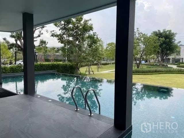ทาวน์เฮาส์ ให้เช่าในBang Phli, Samut Prakan - สระว่ายน้ำขอบอาคารมองเห็นสวนสีเขียวโดยรอบ.