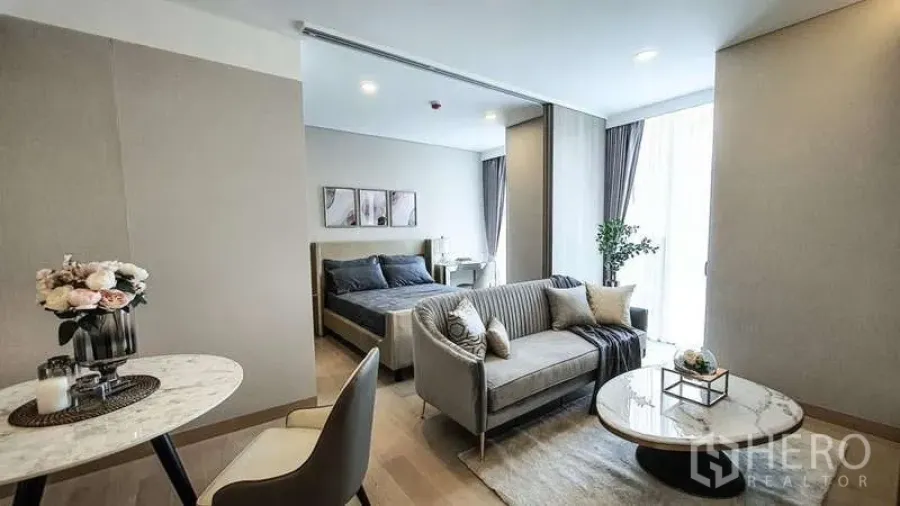 Condominium for sale in Khlong Toei, Bangkok - Full layout showing dining nook, living area, and bedroom flowing to a floor-to-ceiling window.