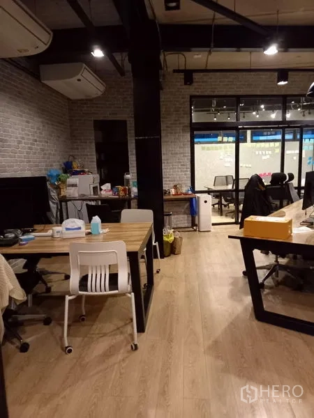 Office Space for rent in Chatuchak, Bangkok - Open-plan office with wood flooring, brick walls, exposed ceiling beams and long workstations.