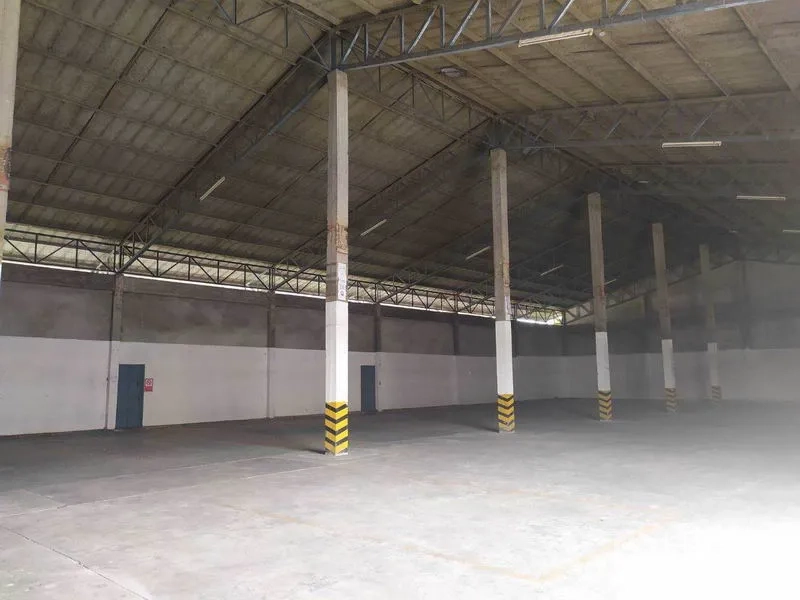 Warehouse for rent in Mueang Samut Prakan, Samut Prakan - Clean storage floor with marked bays, multiple access doors and ventilated gable roof structure.