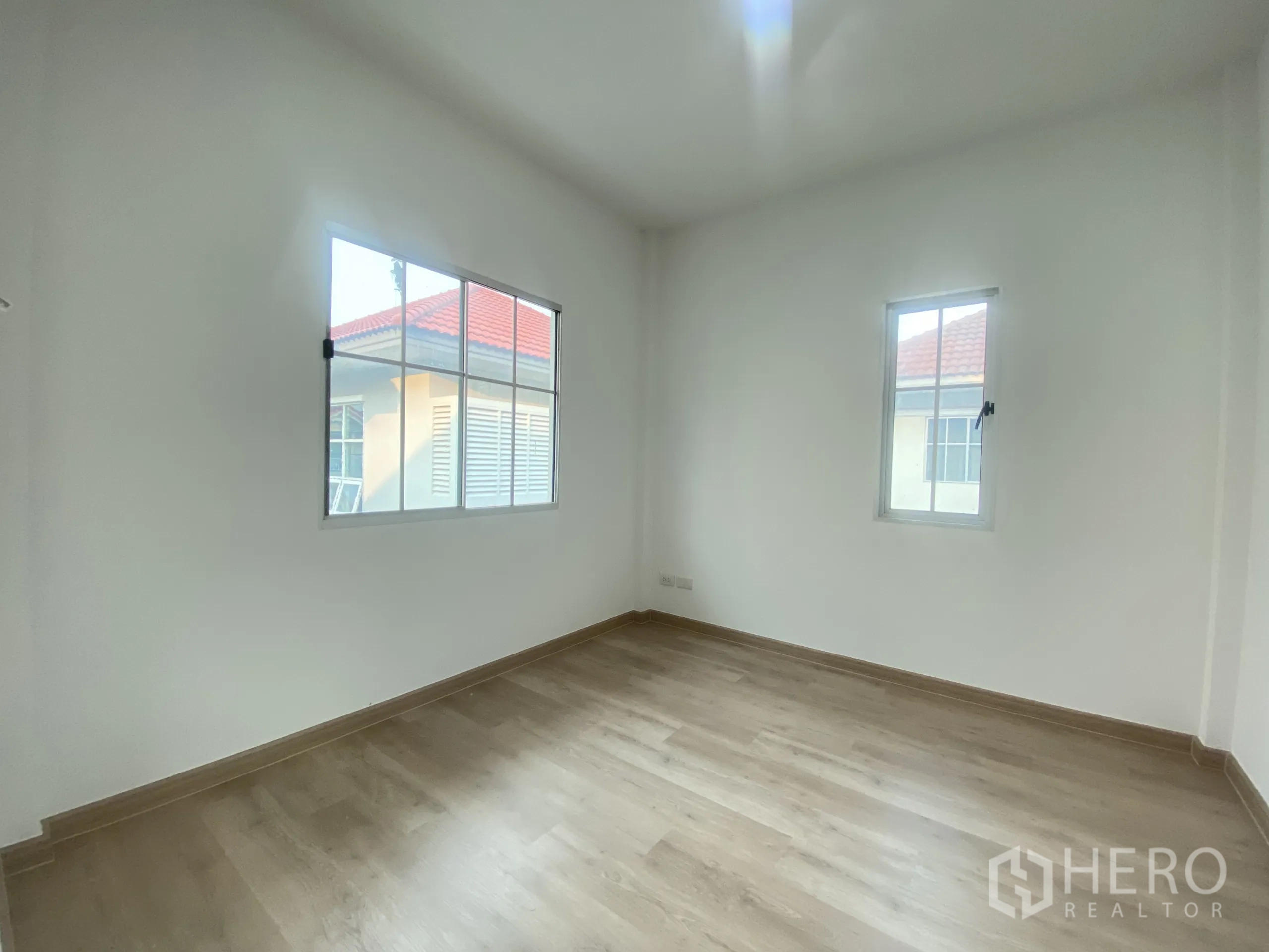 บ้าน ขายในNonthaburi - ห้องนอนสว่างด้วยหน้าต่างสองบาน พื้นไม้ลามิเนตโทนอ่อน.