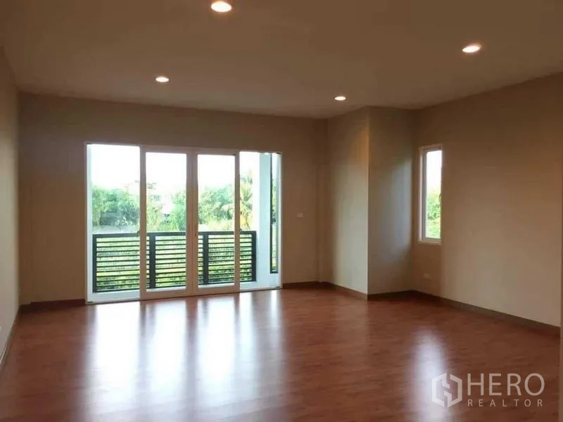 Detached House for sale in Bang Kruai, Nonthaburi - Upper-floor bedroom with wood flooring, recessed lights and doors to a small balcony.