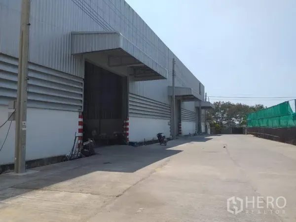 คลังสินค้า ให้เช่าในPak Kret, Nonthaburi - ด้านหน้าโกดังสมัยใหม่ มีชายคาท่าขนถ่ายและลานคอนกว้างในเขตปากเกร็ด