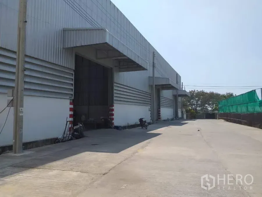 คลังสินค้า ให้เช่าในPak Kret, Nonthaburi - ด้านหน้าโกดังสมัยใหม่ มีชายคาท่าขนถ่ายและลานคอนกว้างในเขตปากเกร็ด
