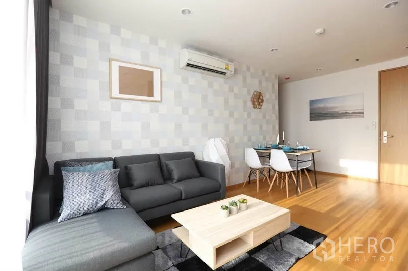 公寓 出租或出售在Bang Rak, Bangkok - 客厅配L型沙发、茶几与餐桌，木地板温暖