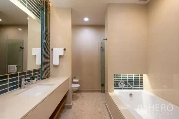Condominium for rent in Bang Kho Laem, Bangkok - Spacious bathroom with long vanity, bathtub and separate glass shower.