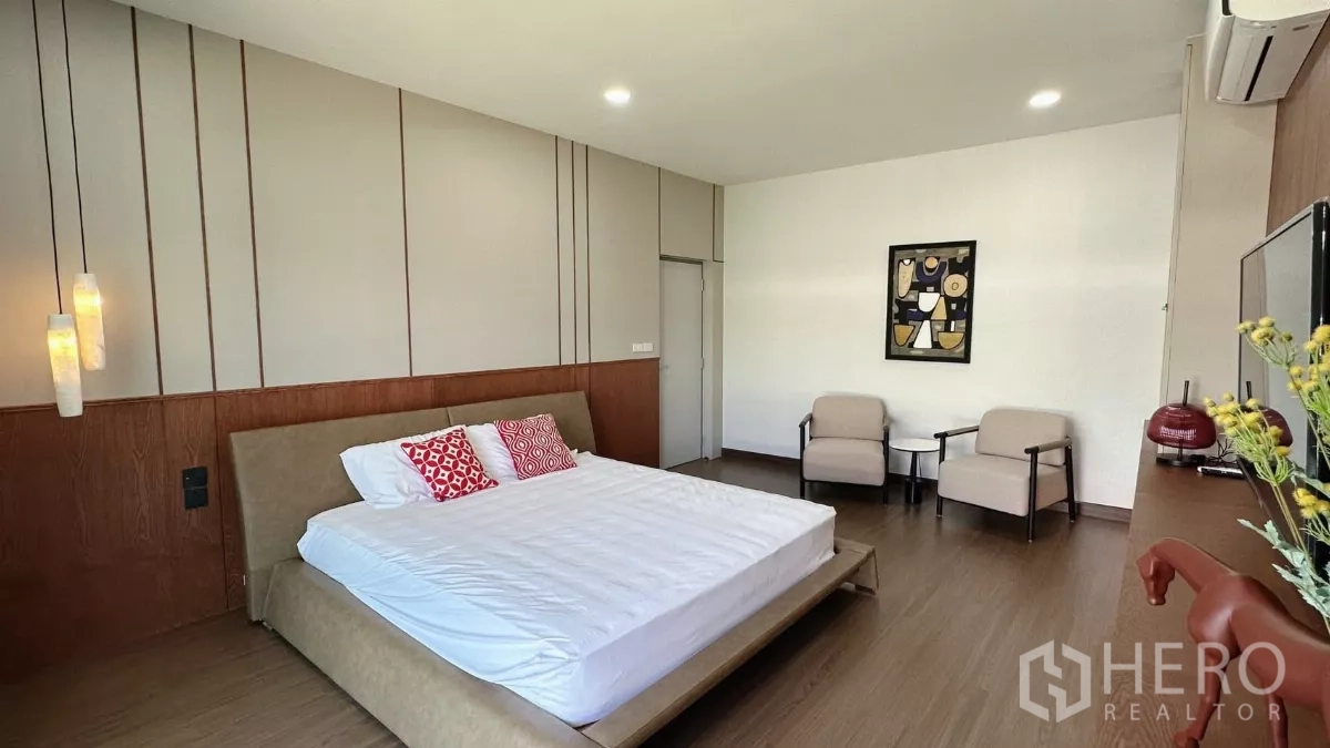บ้าน ให้เช่าในBang Phli, Samut Prakan - วิวห้องนอนใหญ่ เตียงคิงไซส์ โคมไฟแขวน และเก้าอี้พักผ่อน