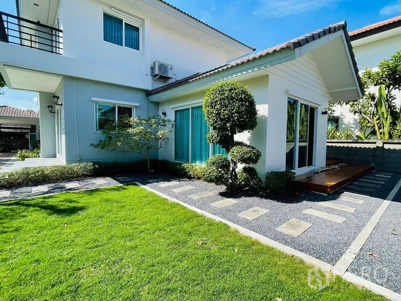 Detached House for sale in Lam Luk Ka, Pathum Thani - Garden view of single-storey extension with sliding glass doors and sculpted topiary.